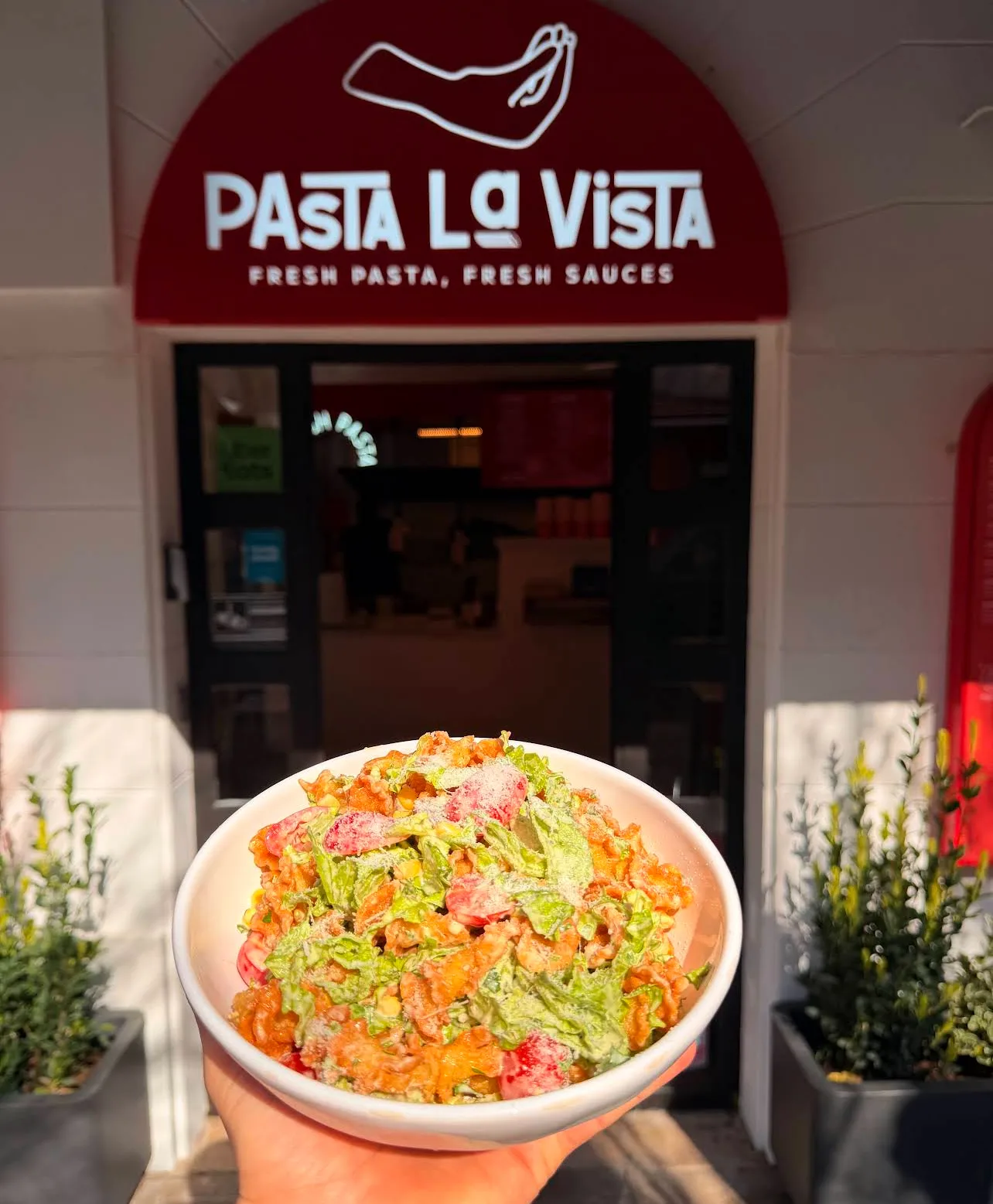 Bol de pâtes fraîches Pasta La Vista tenu devant la façade du restaurant à Bergerac
